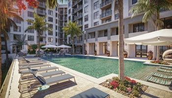 Heated resort-style salt water swimming pool with lounge chairs outside Indigo residential buildings